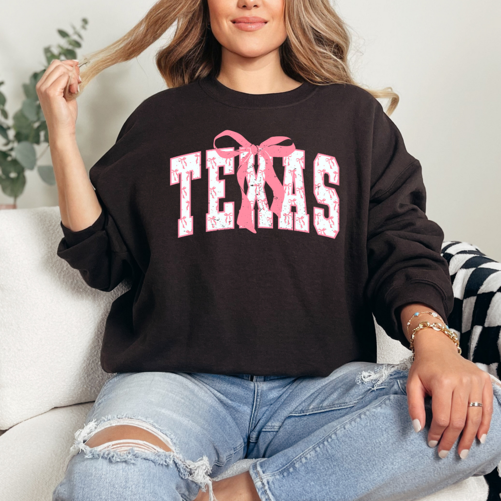 Graphic Texas letters with pink and white bows within texas letters. Cute pink bow centered above X in texas. Chic modern design. Chocolate Brown sweater