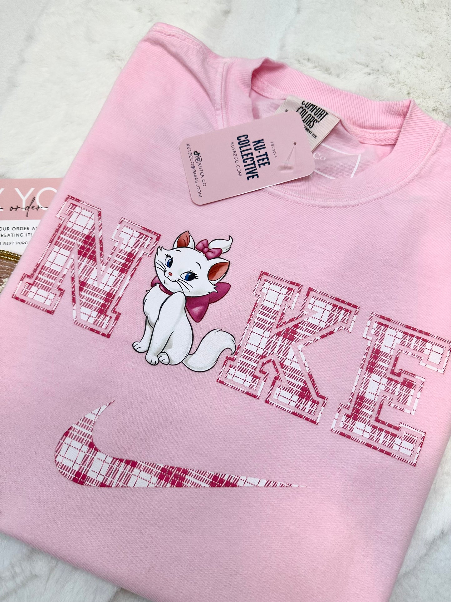 Pink sweatshirt with aristocat cartoon cat design and text on a white background