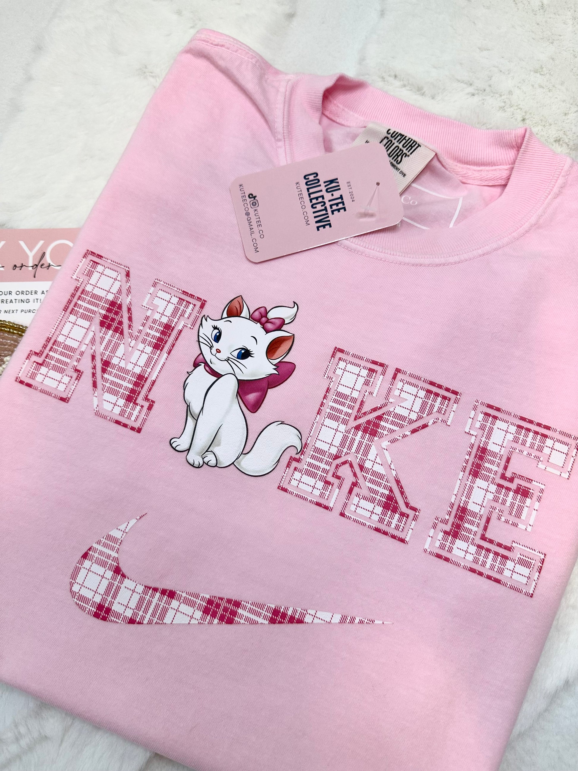 Pink sweatshirt with aristocat cartoon cat design and text on a white background